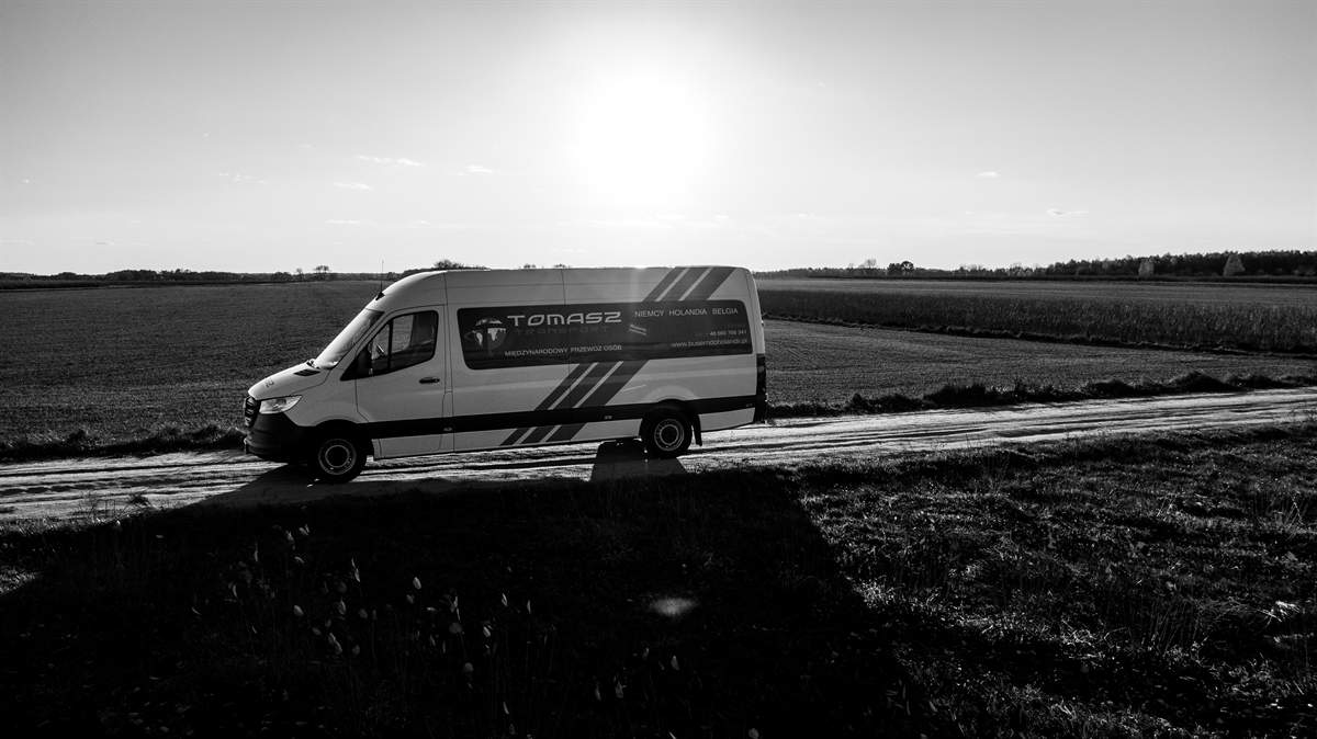 Bus Tomasz Transport pod słońce — zdjęcie czarno-białe