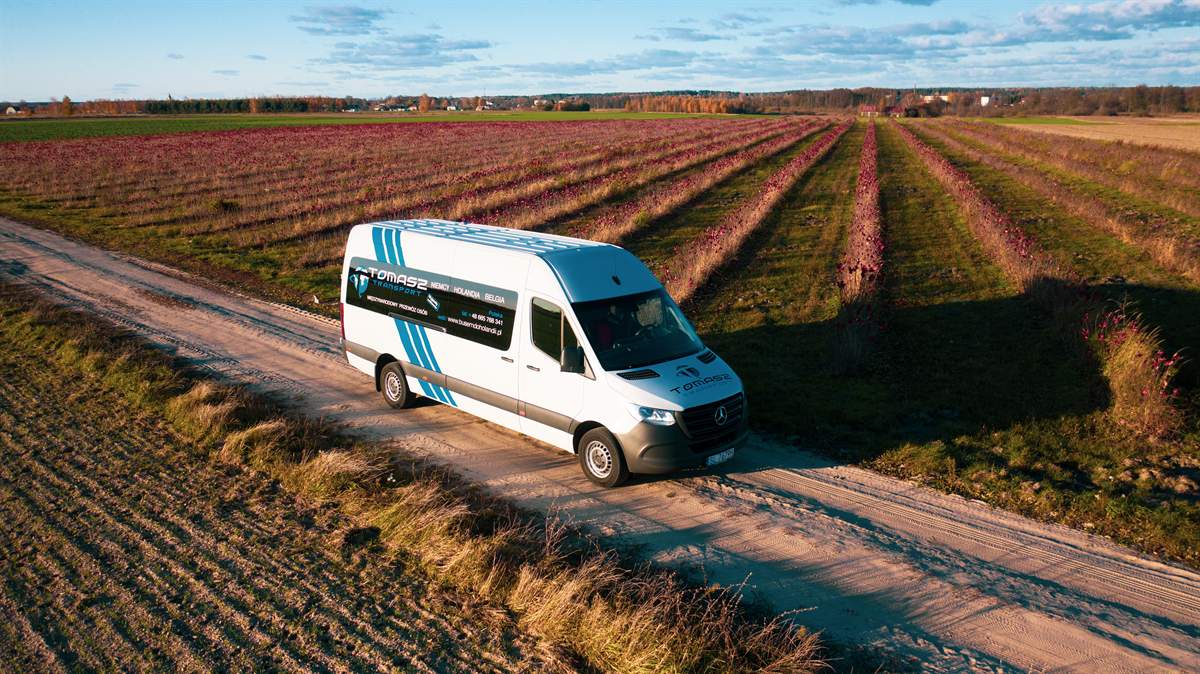 Bus Tomasz Transport na drodze między polami