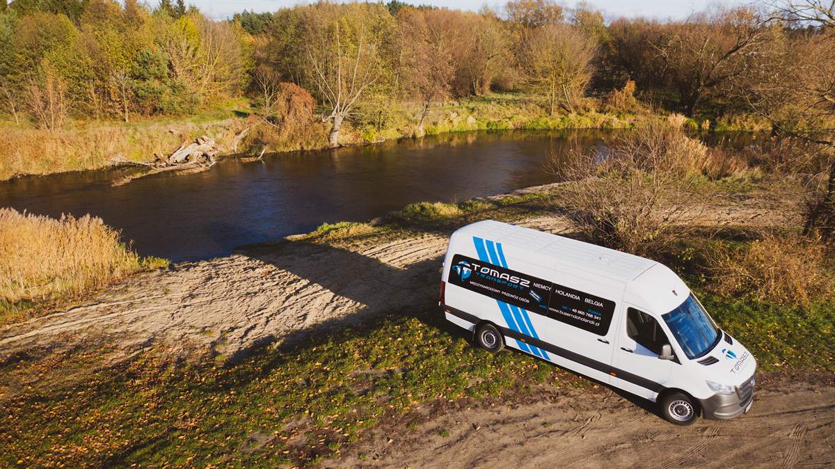 Przewóz osób busem do Holandii — bus nad rzeką